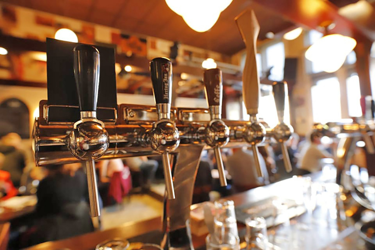 Diverse bierkranen op een bar.