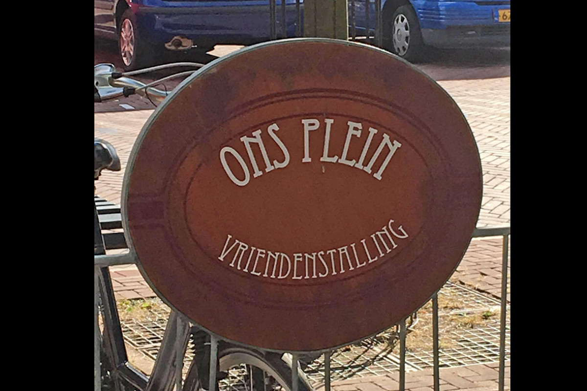 Fietsenrek met bord 'Café Ons Plein'.