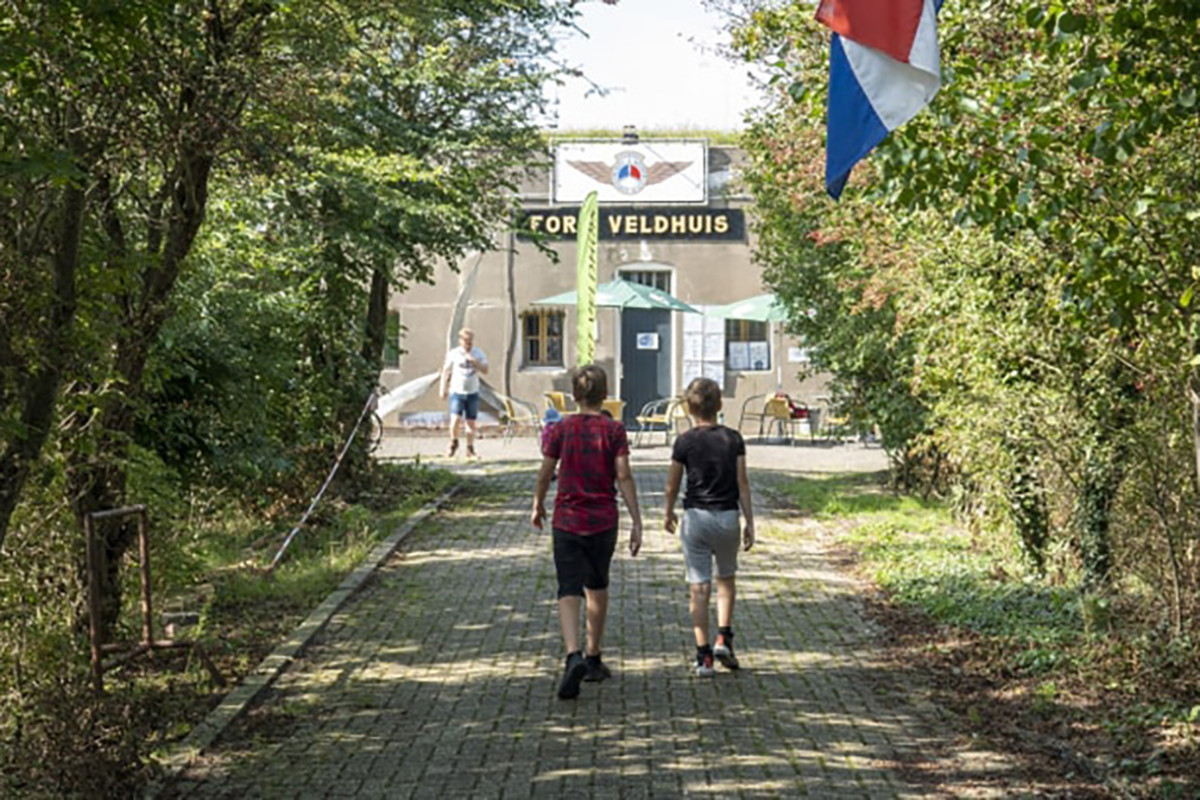 Twee jongens lopen over een pad naar Fort Veldhuis.