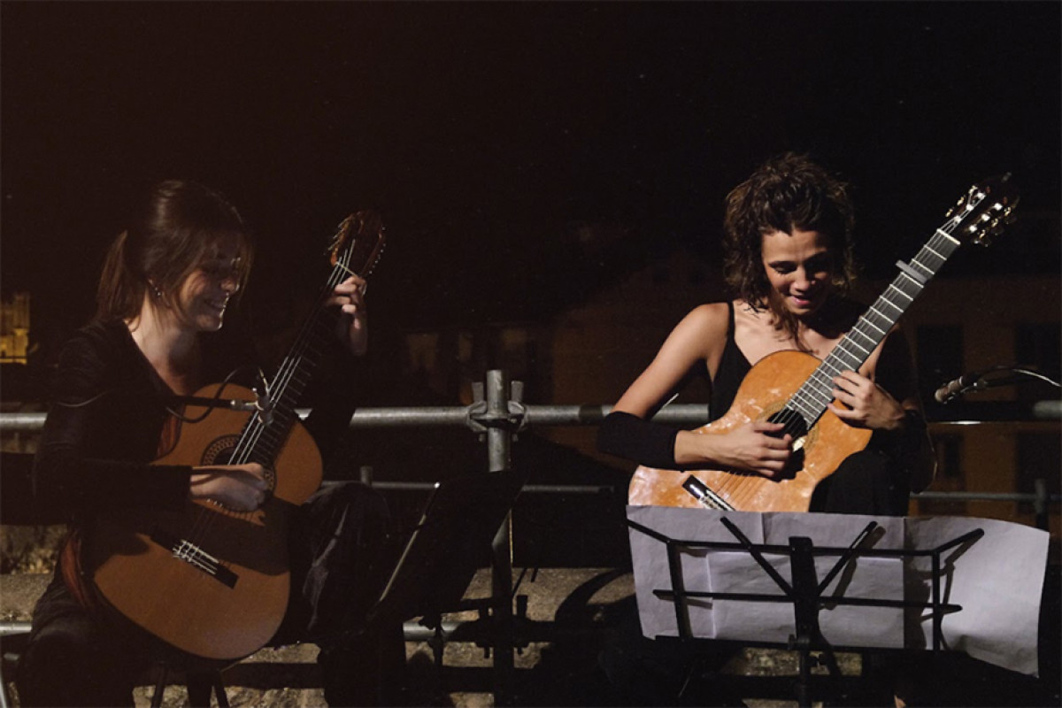 Twee vrouwen op podium met spaanse gitaar