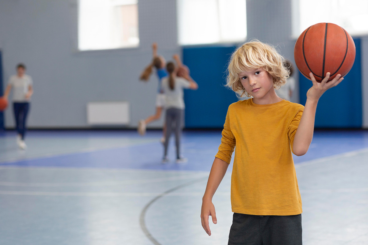 Jongen in gymzaal met bal