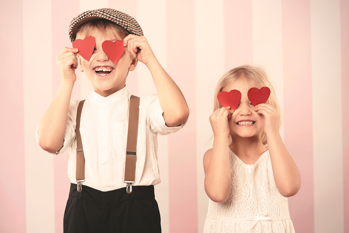 Jongen en meisje hebben papieren hartjes voor hun ogen