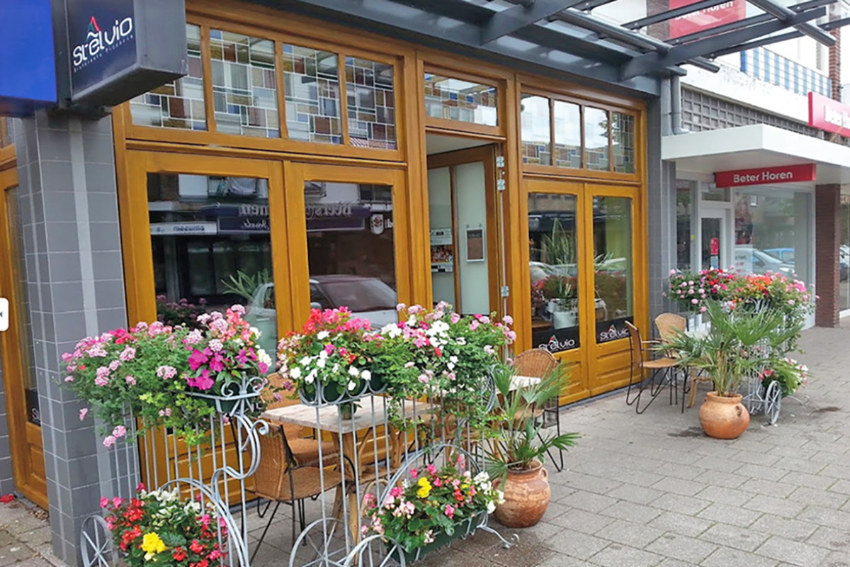 Buitenkant Pizzeria Da Pietro met fleurige bloemenbakken voor de deur.