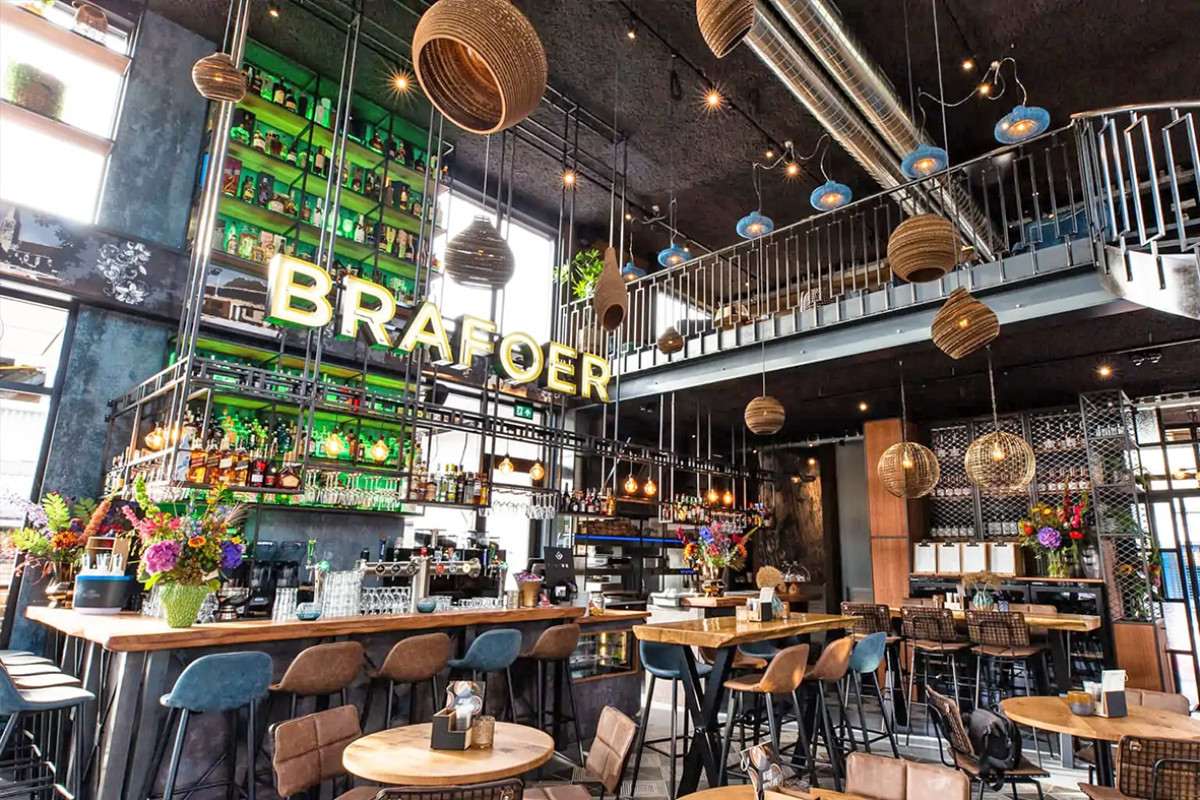 Interieur van Restaurant Brafoer met bar en tafels en stoelen.