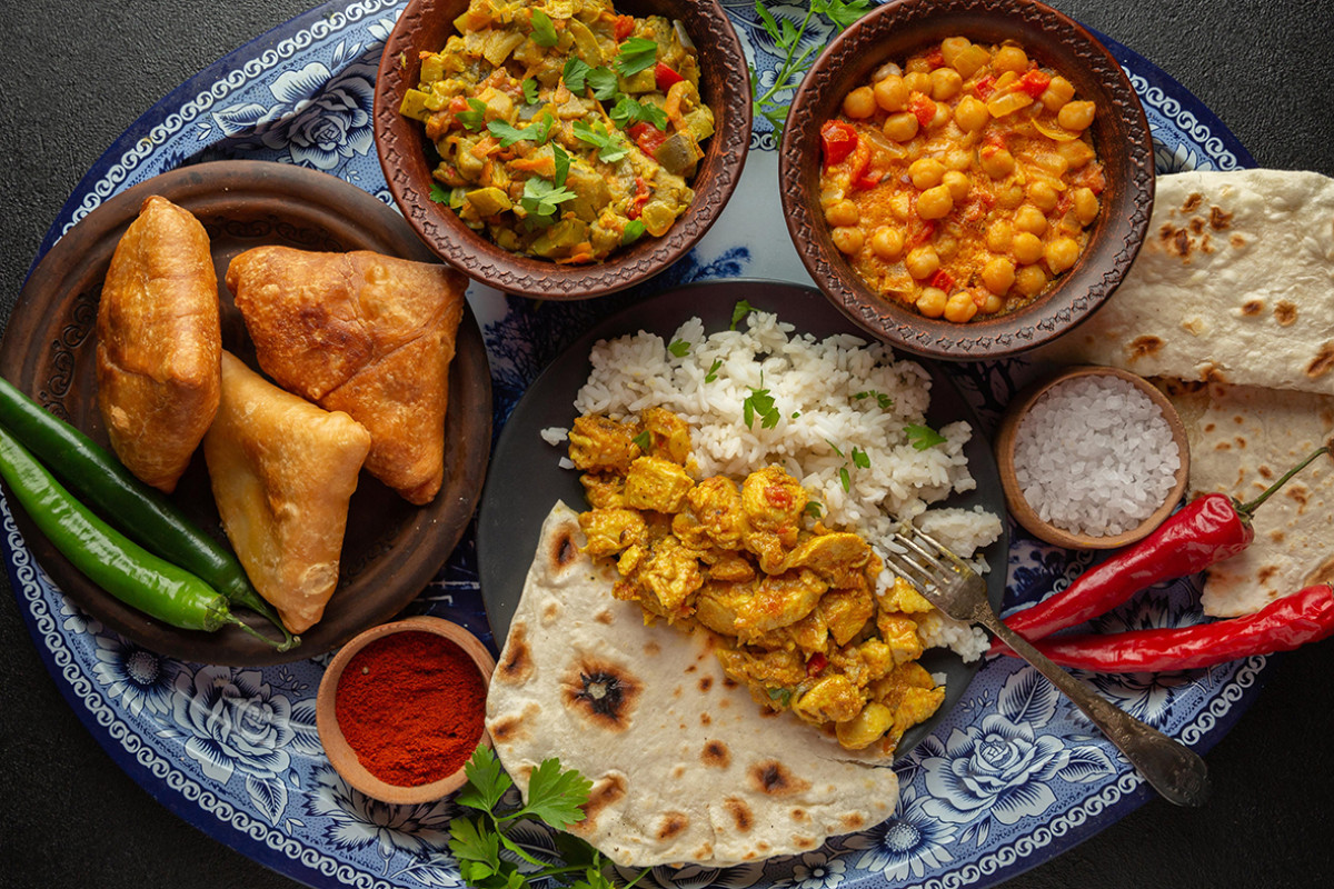 Indisch eten op een bord met rijst, bonen en andere gerechten. Heerlijke smaken uit India.