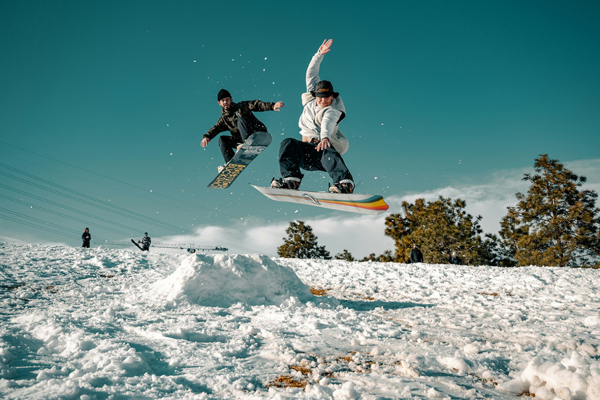 Twee personen op snowboards, genietend van de besneeuwde hellingen tijdens een wintersportavontuur.