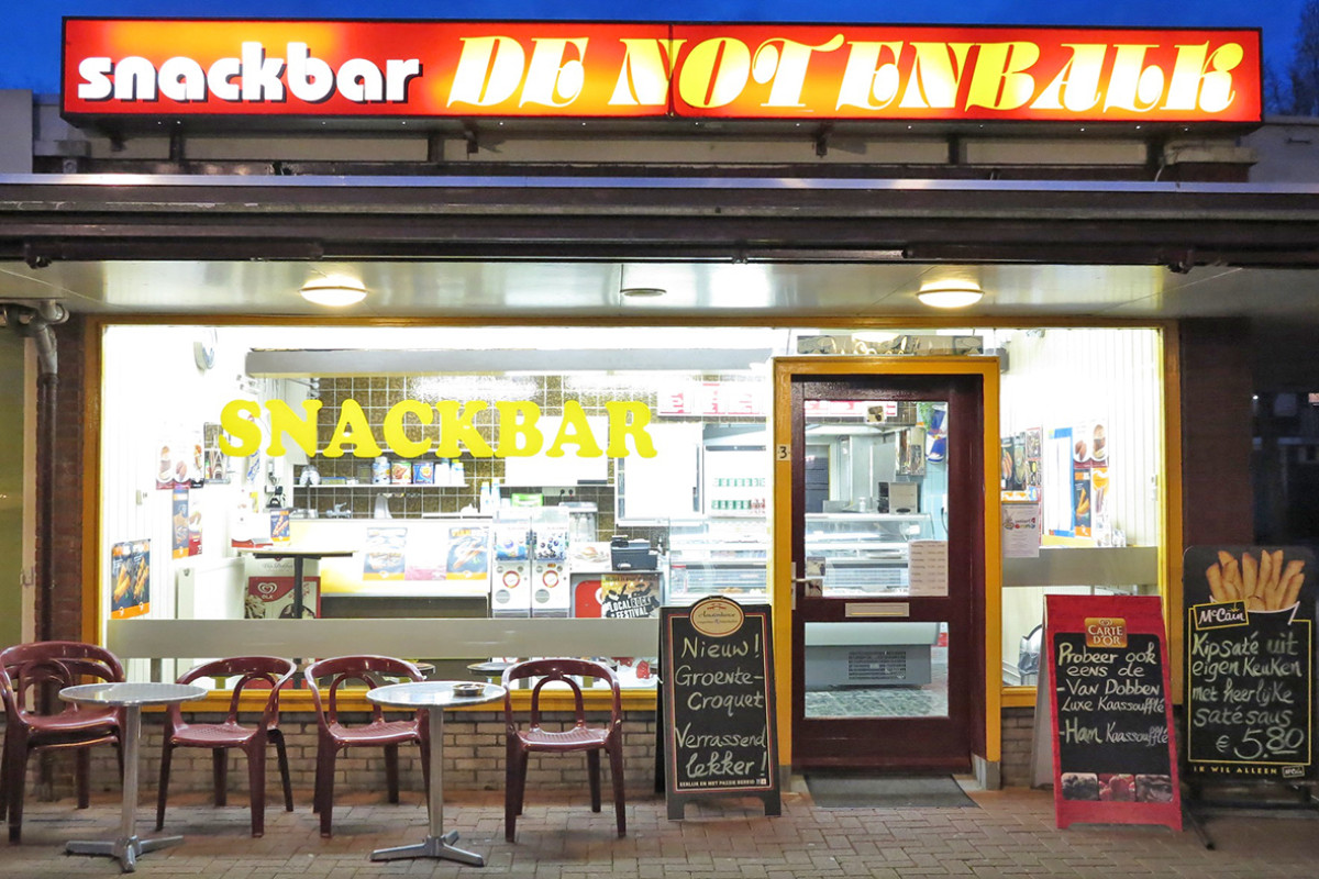 Buitenkant van Snackbar de Notenbalk, binnen brand licht.