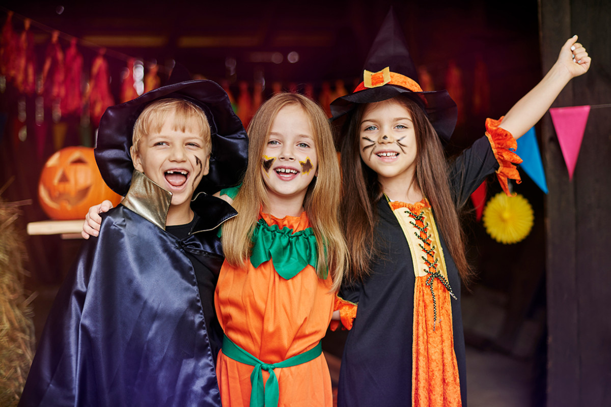 3 kinderen staan verkleed in halloweenkostuums