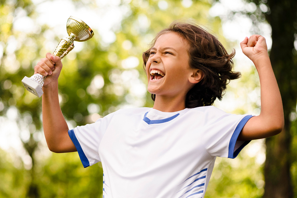 Jongen in sporttenue houdt prijs vast