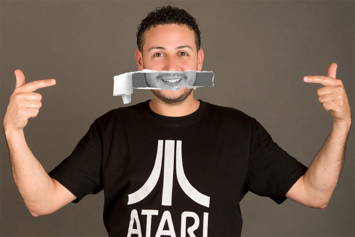 Man met zwart atari shirt heeft een zwart print over z'n mond